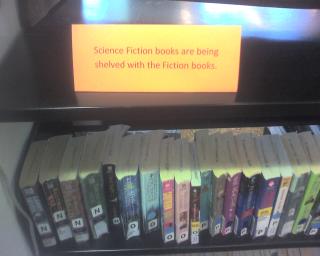 Picture of sign: Science Fiction books are being shelved with the Fiction books.