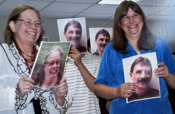 Wonderful support staff, Mary Scott and Queenie Kravitz holding photos of colleagues Bonnie John and Scott Hudson