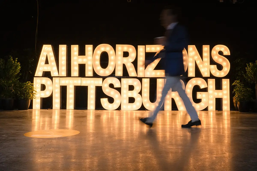  A blurred human walks in front of an illuminated sign that says AI Horizons Pittsburgh.