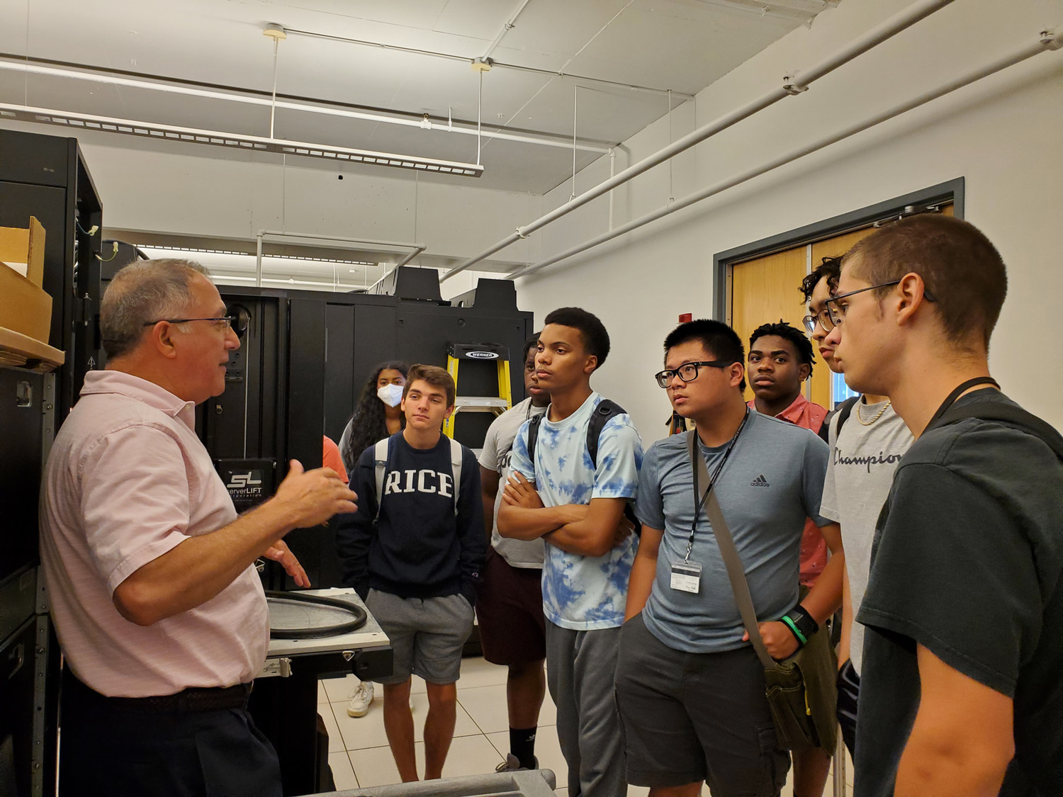 High school students in a group listening to a faculty member.