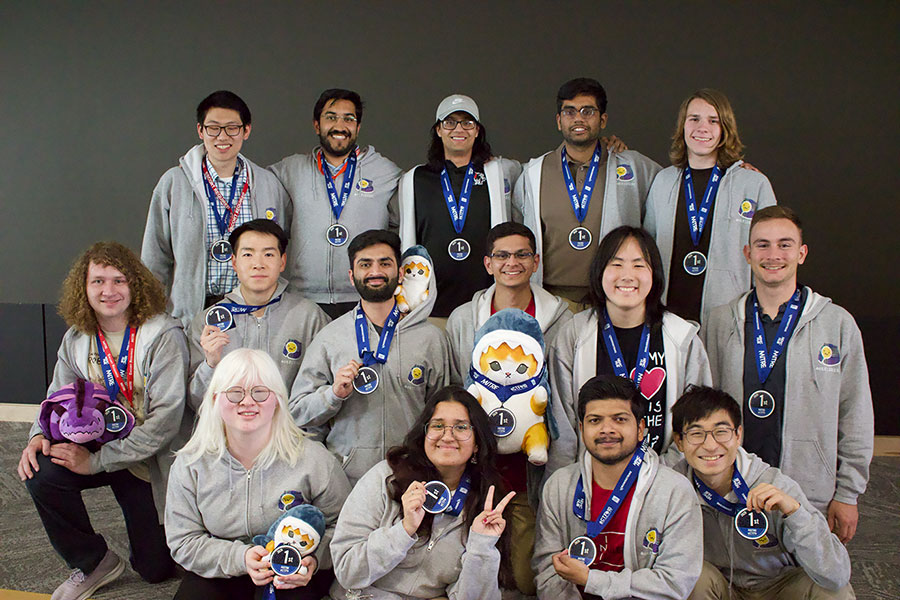  A group of students wearing medals pose for a photo.