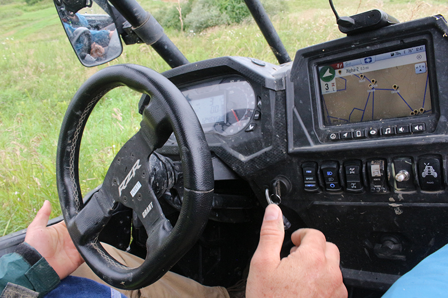 The steering wheel of an ATV, with the driver's hands noticably removed from it as it drives itself. A map display is seen on the right of the photo.