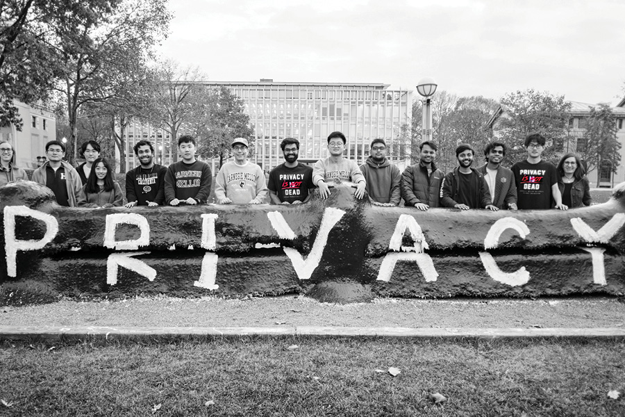  CMU Privacy Engineering students stand in front of the Fence on CMU's campus with the word Privacy painted on it