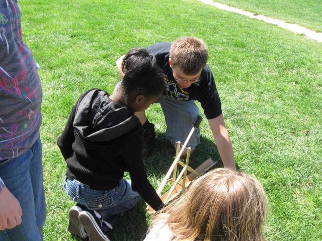 Child learning how to launch trebuchet
